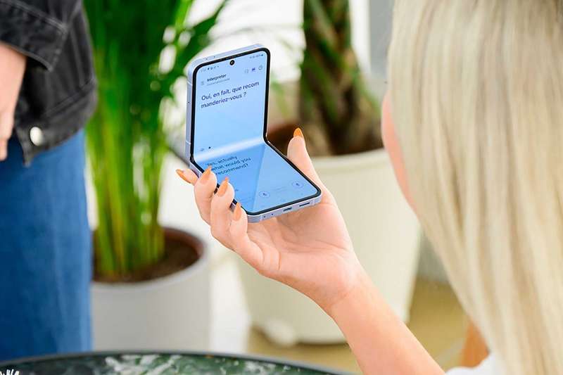 زنی که سامسونگ گلکسی Z Flip 7 را با استفاده از برنامه مترجم در دست دارد