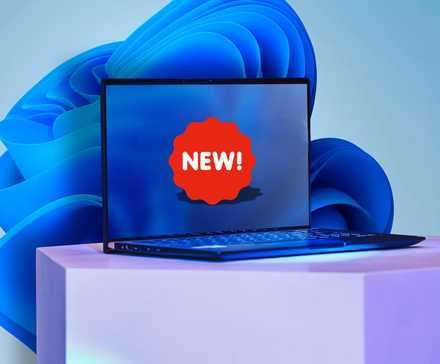 لپ‌تاپ با برچسب NEW روی صفحه و تصویر پس‌زمینه ویندوز ۱۱