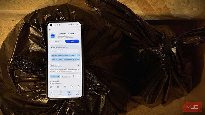 یک گوشی هوشمند روی یک کیسه زباله با برنامه Outlook مایکروسافت روی نمایش