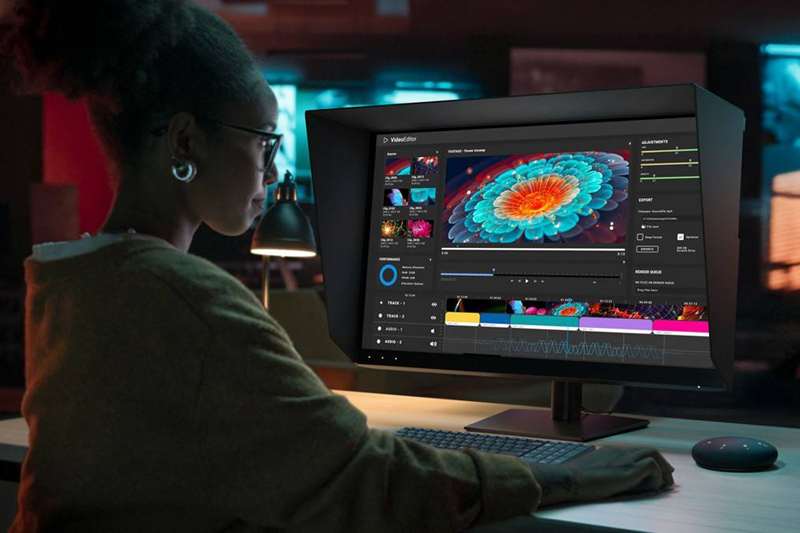 زنی که از مانیتور Dell UltraSharp 32 4K QD-OLED بر روی یک میز استفاده میکند.