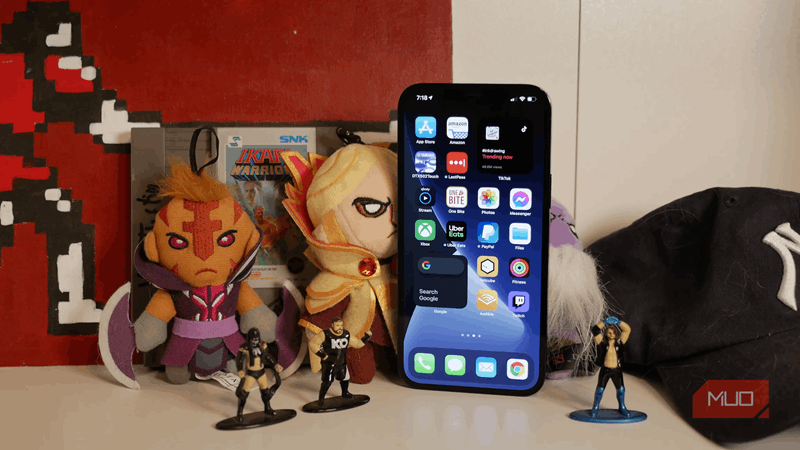 آیفون ۱۲ پرو مکس با اسباب‌بازی‌ها روی قفسه نمای جلویی