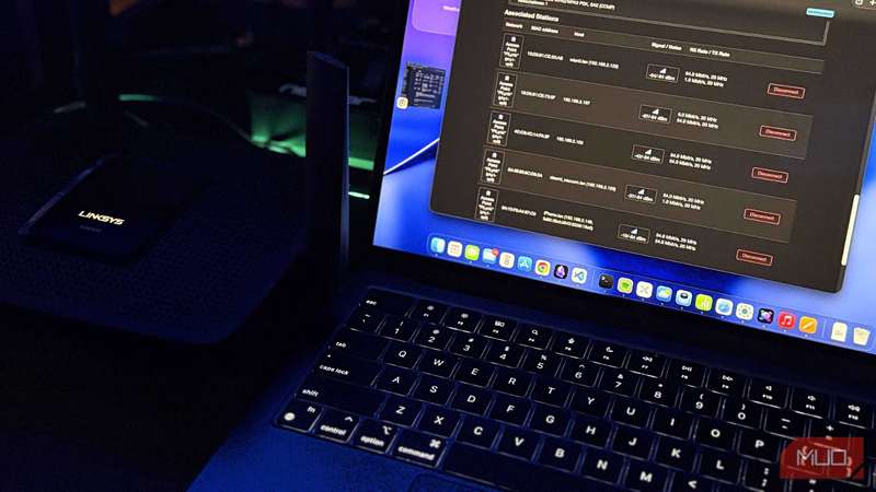 لپ‌تاپی کنار یک روتر Linksys که پنل مدیریت OpenWRT را نشان می‌دهد