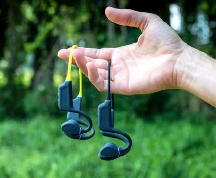 مردی که هدفون هدایت استخوانی را در دست دارد-1