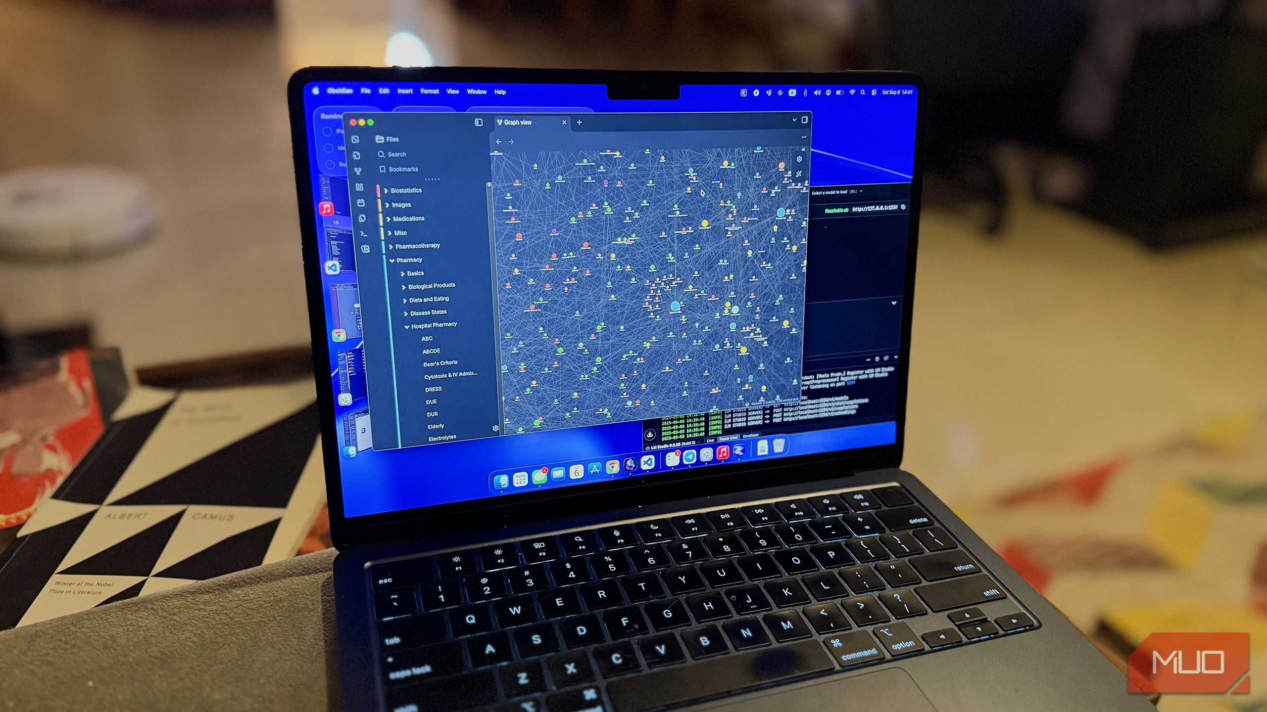 یک مکبوک روی مبل که نمای گراف Obsidian و LLM محلی را نشان میدهد