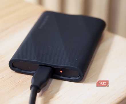 یک SSD پرتابل Samsung T9 که با نور وضعیت LED نارنجی در حال انتقال داده‌ها است.