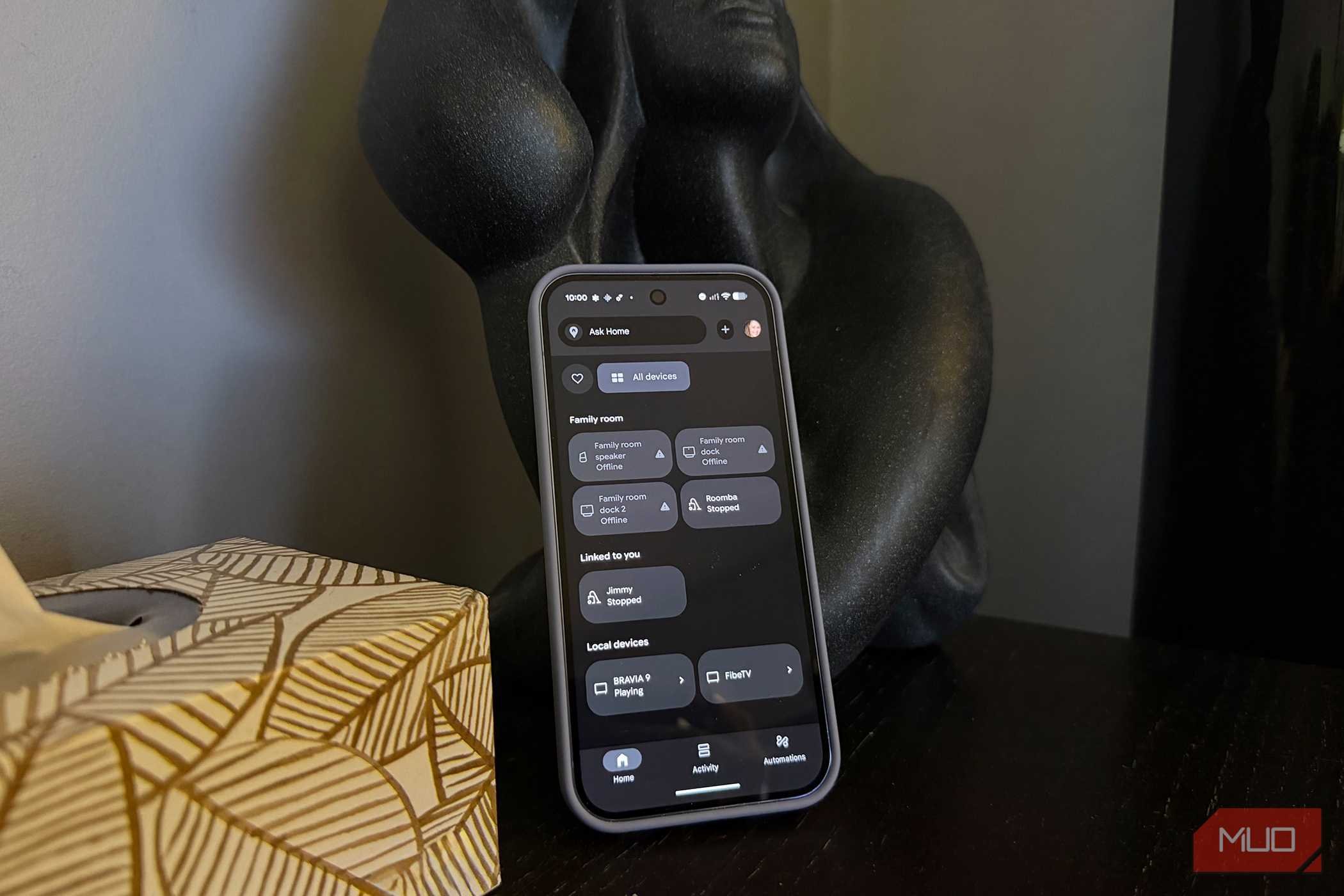 یک گوشی اندروید روی میز جانبی قرار گرفته که منوی کنترل خانه هوشمند را نشان میدهد