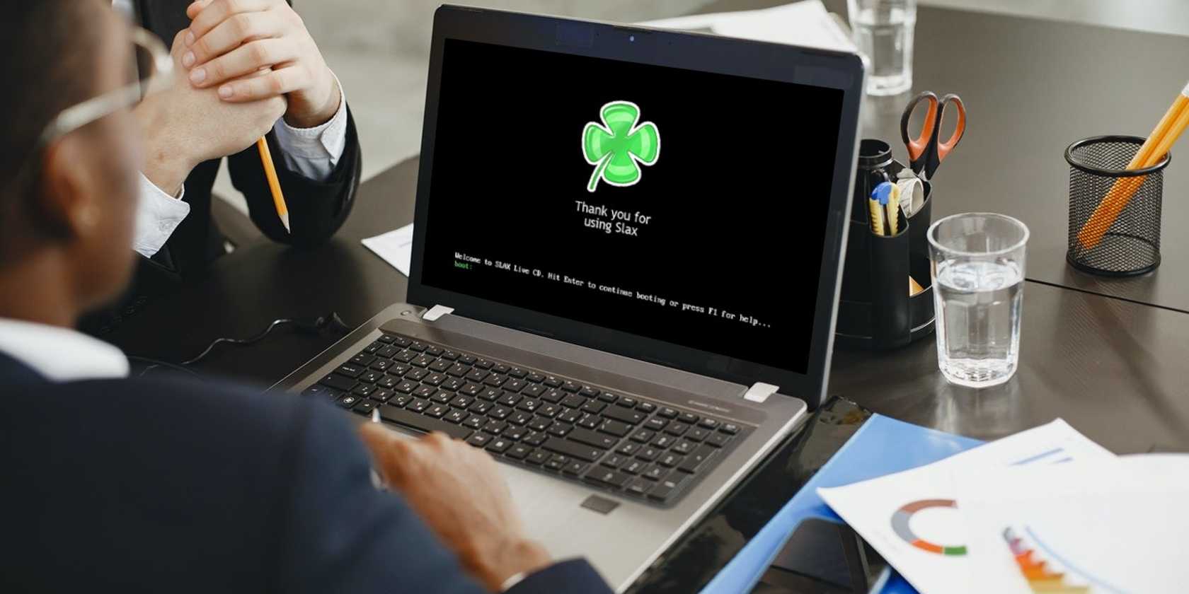 مردی که با لپتاپ از صفحهٔ بوت Slax استفاده میکند