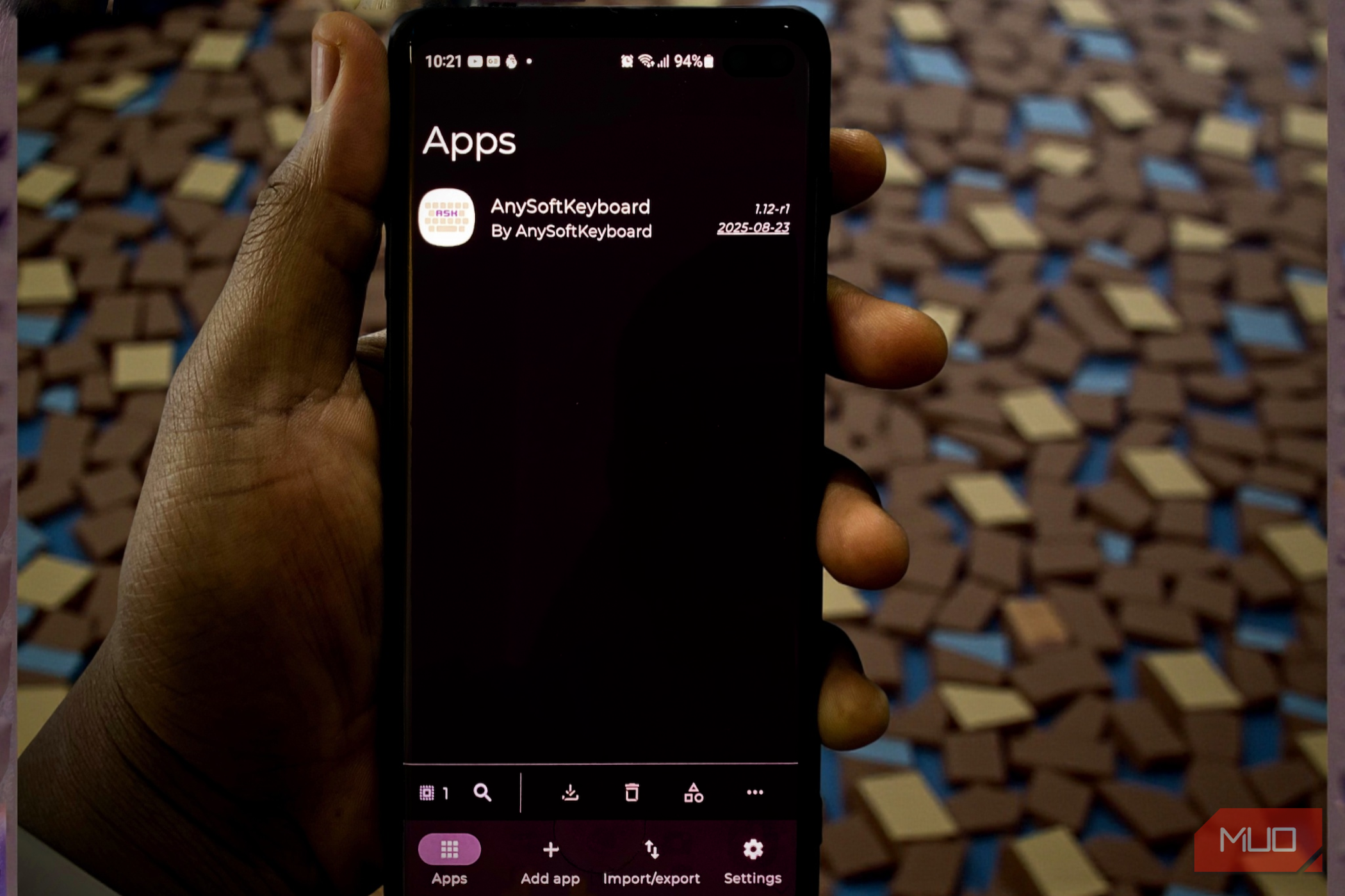 دست که یک گوشی هوشمند را نشان میدهد که داشبورد برنامه Obtainium را نمایش میدهد