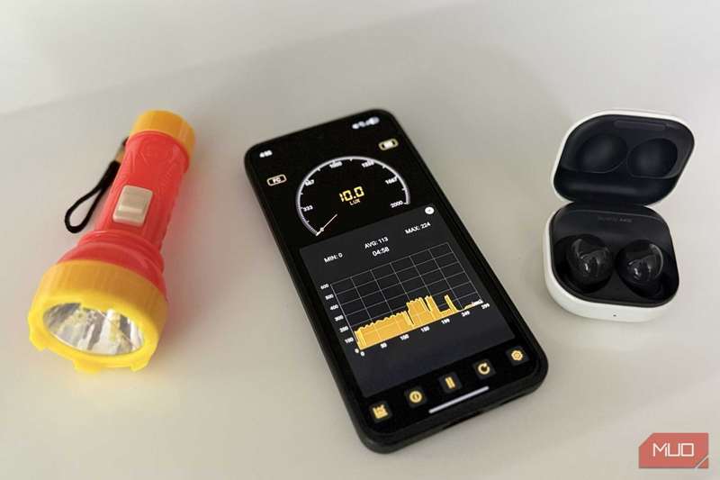 تلفن اندروید با یک چراغ قوه و هدفون در کنار آن