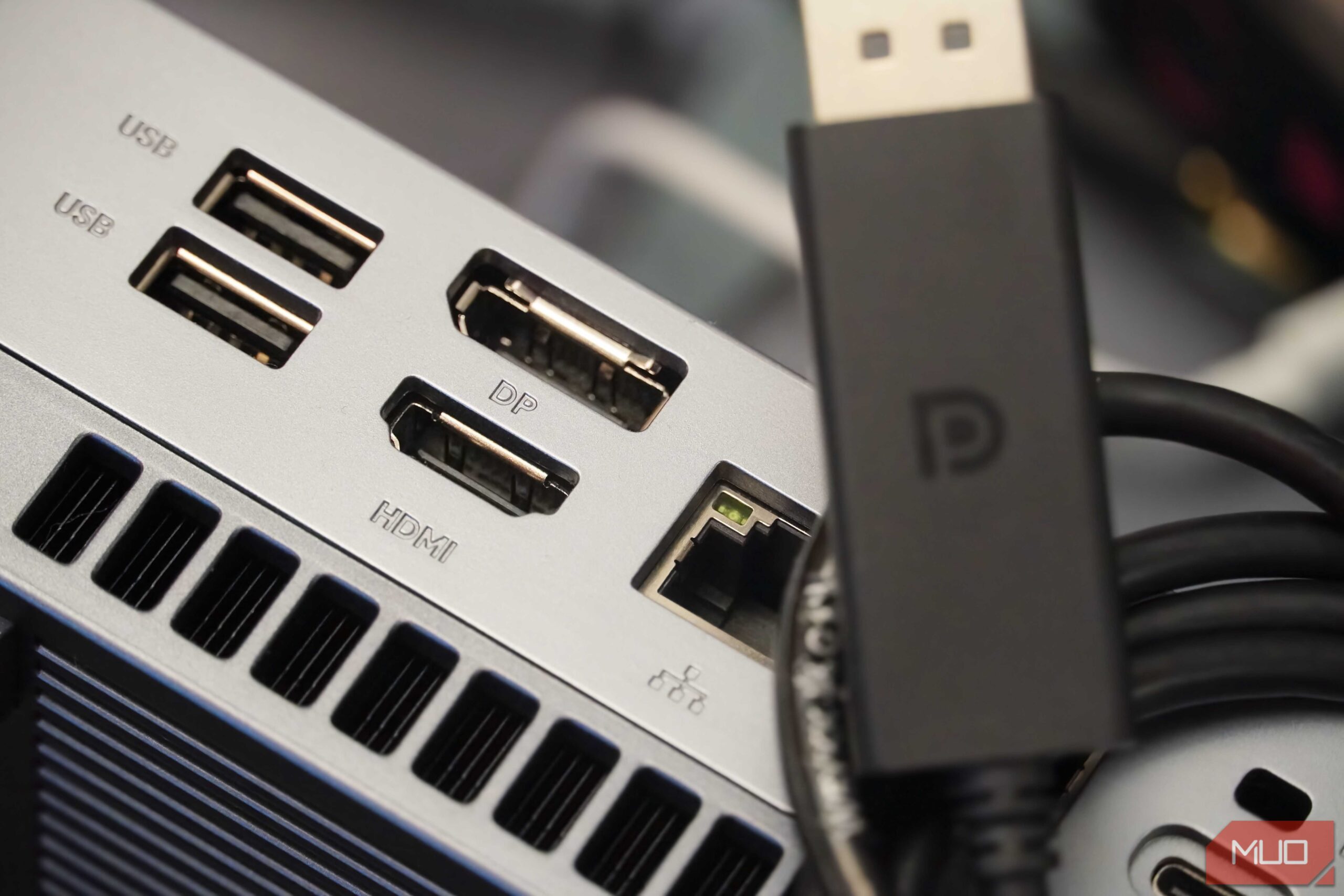 کابل DisplayPort روی یک Mini PC با ورودیهای DP و HDMI قرار گرفته است