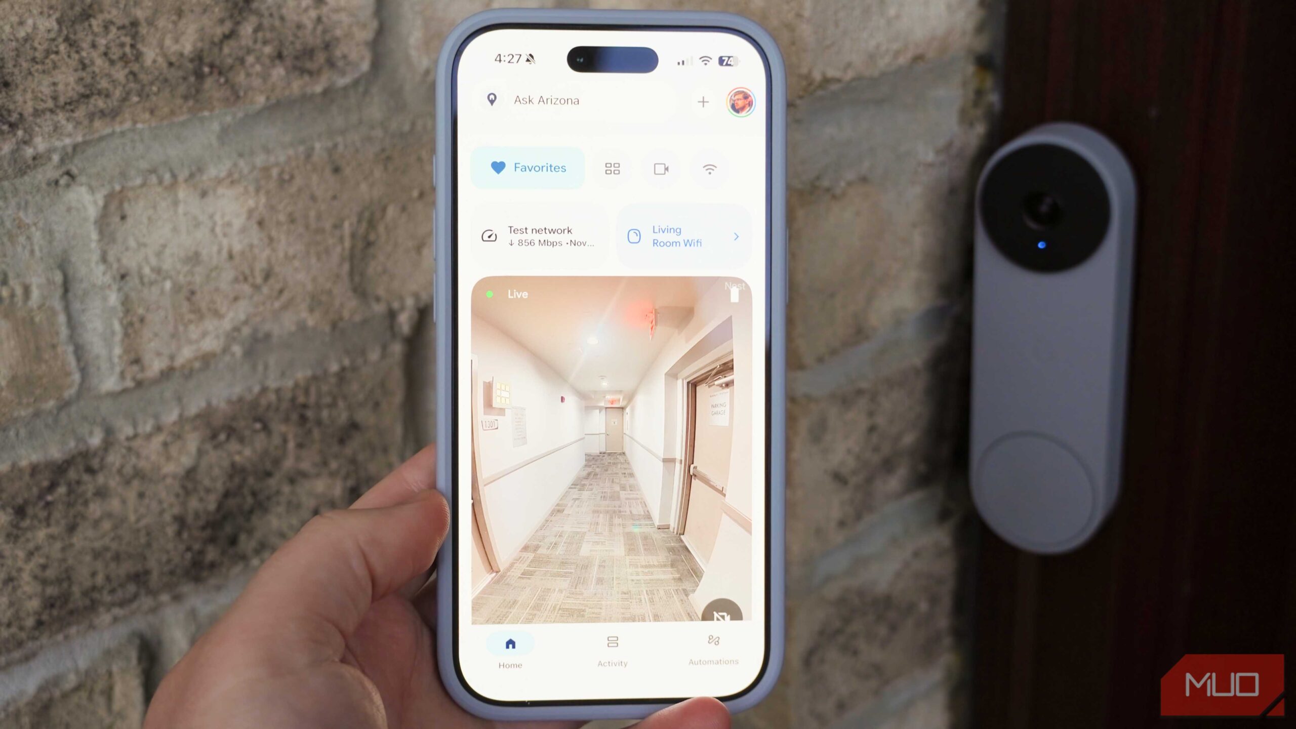 برنامه Google Home روی iPhone با زنگ در Google Nest در پس‌زمینه.