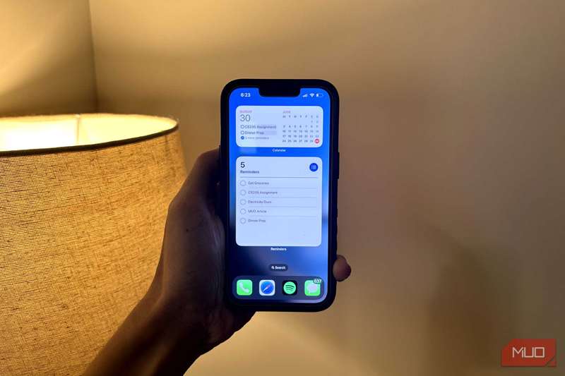 مردی که یک آیفون را در حال نشان دادن ویجت تقویم و یادآورها در دست دارد