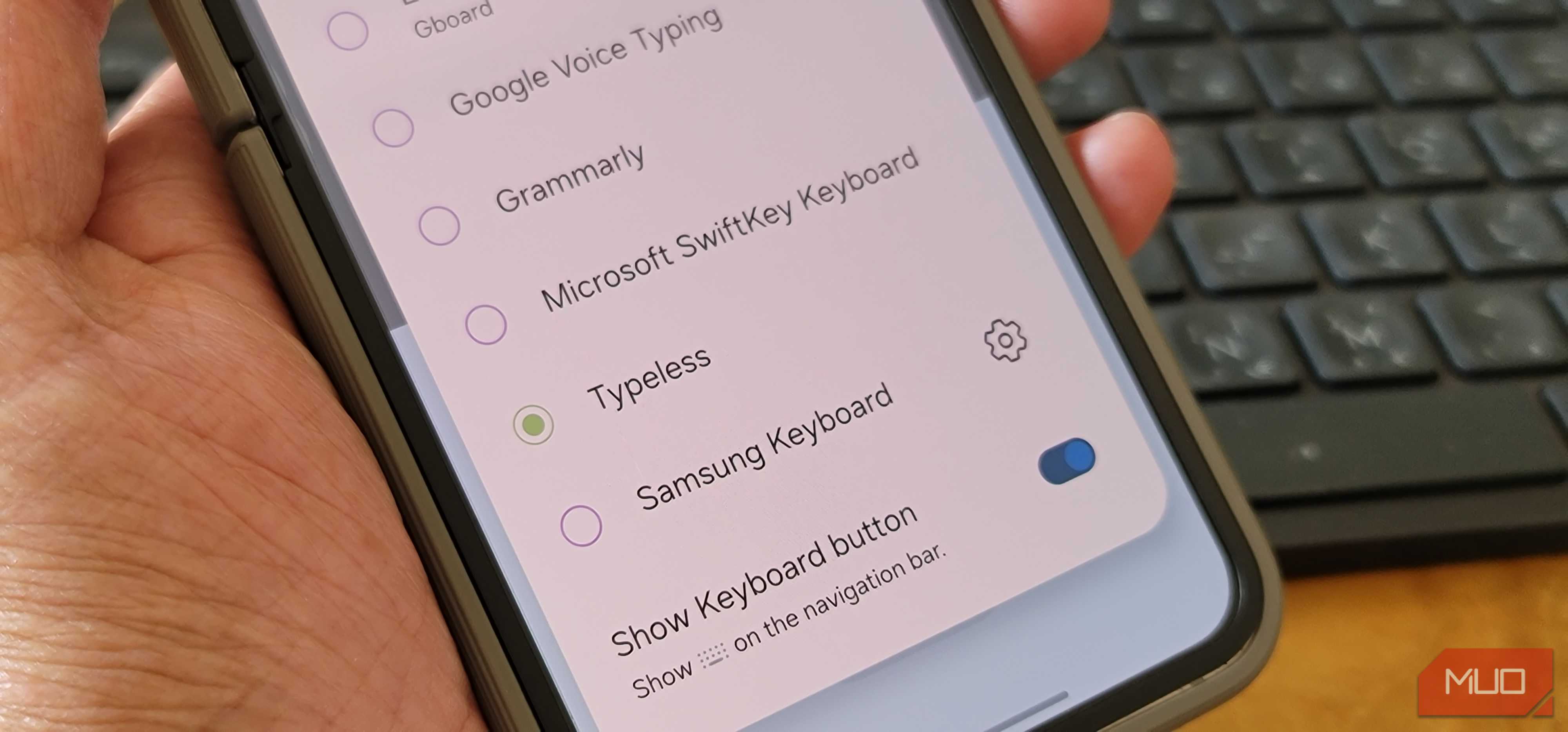 گزینه‌های متعدد صفحه کلید قابل مشاهده با Typeless و Swift Keyboard روی یک Samsung Galaxy Z Flip 6 که توسط یک شخص در دست نگه داشته شده است
