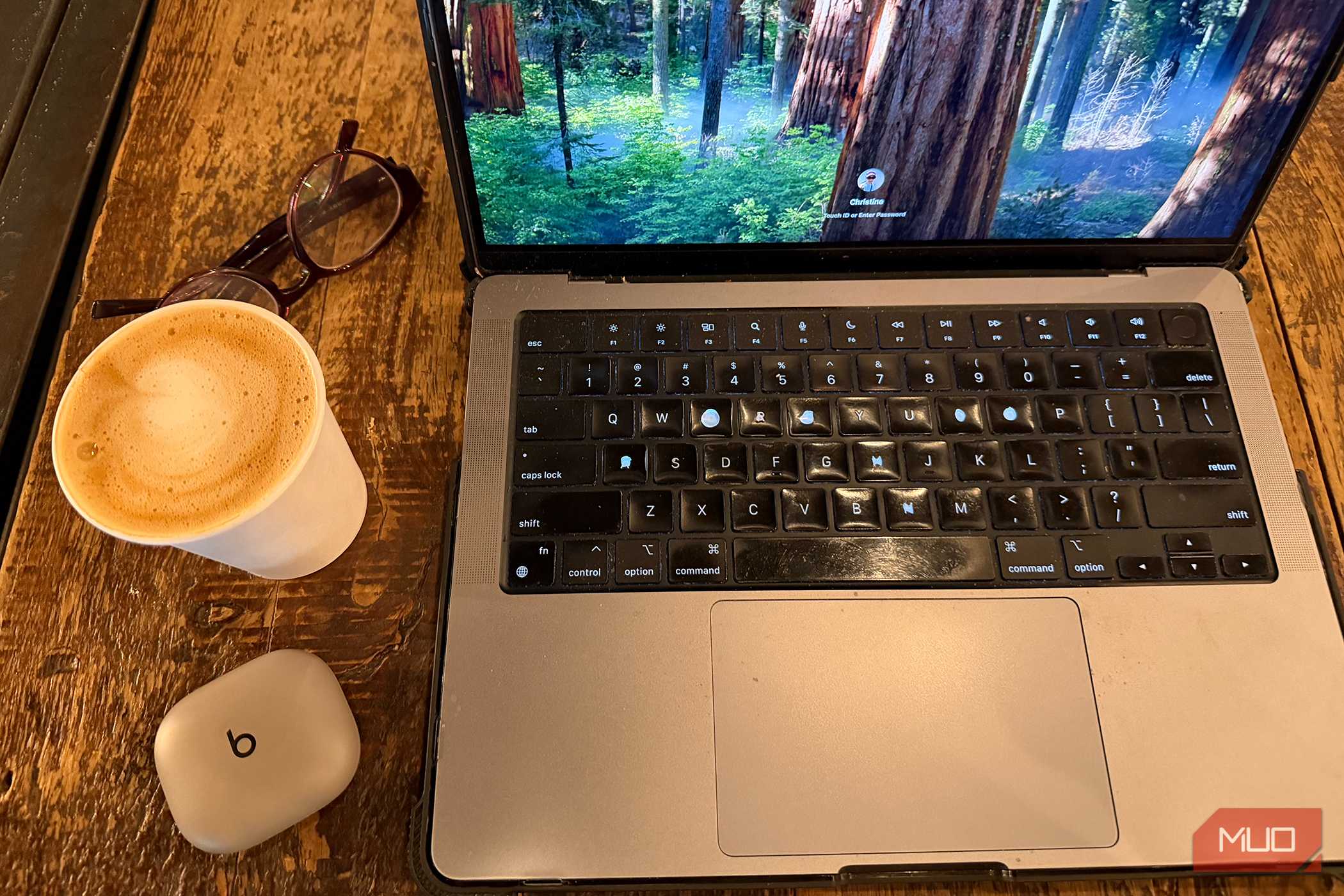 نمایی از Powerbeats Fit به همراه یک فنجان قهوه و لپتاپ.