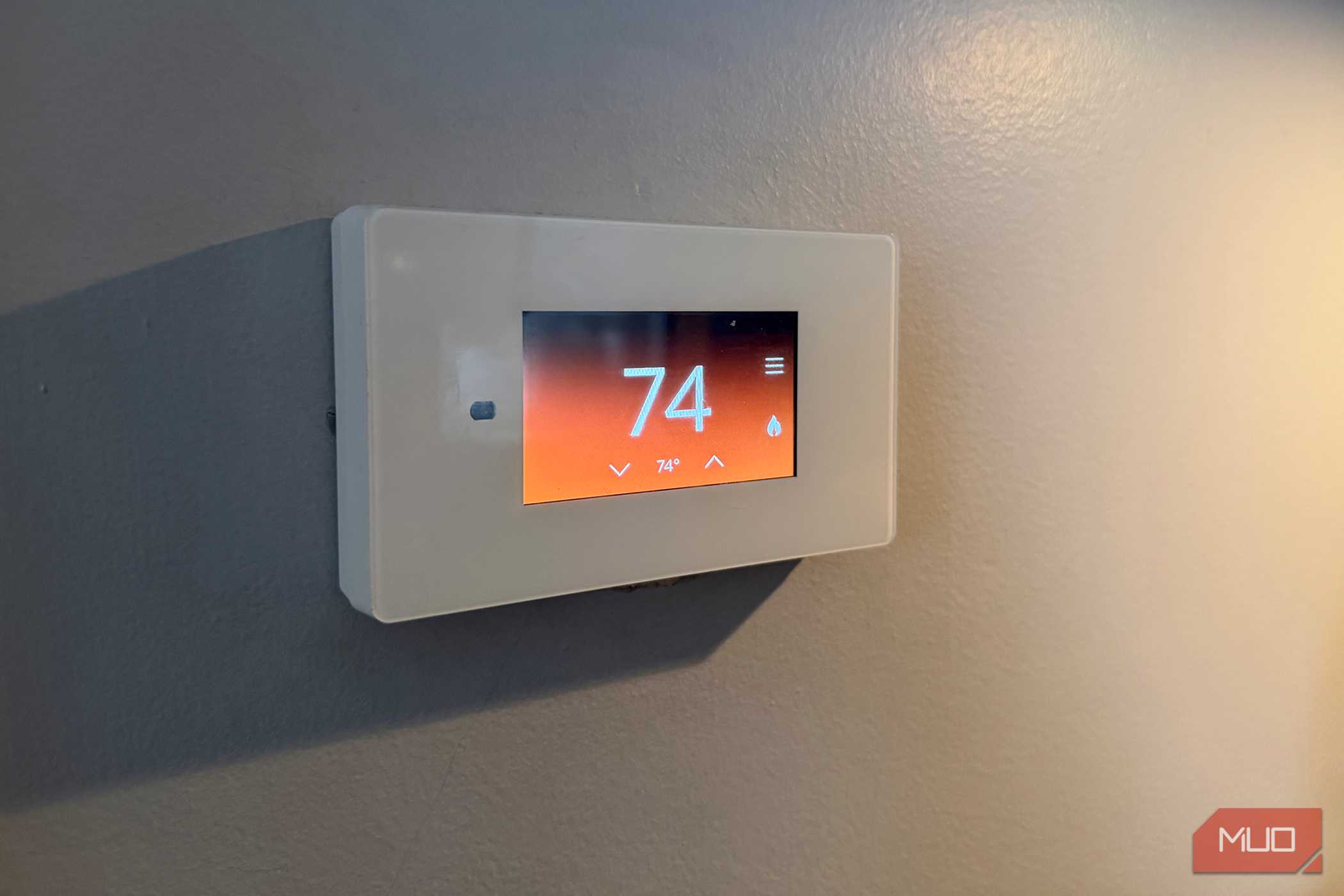 یک ترموستات هوشمند روی دیوار که نشانگر گرمکردن است