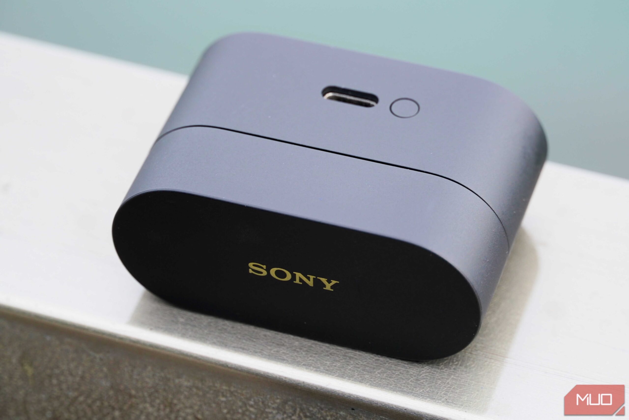 کیس شارژ هدفونهای Sony WF-1000XM6 روی یک ریلینگ.