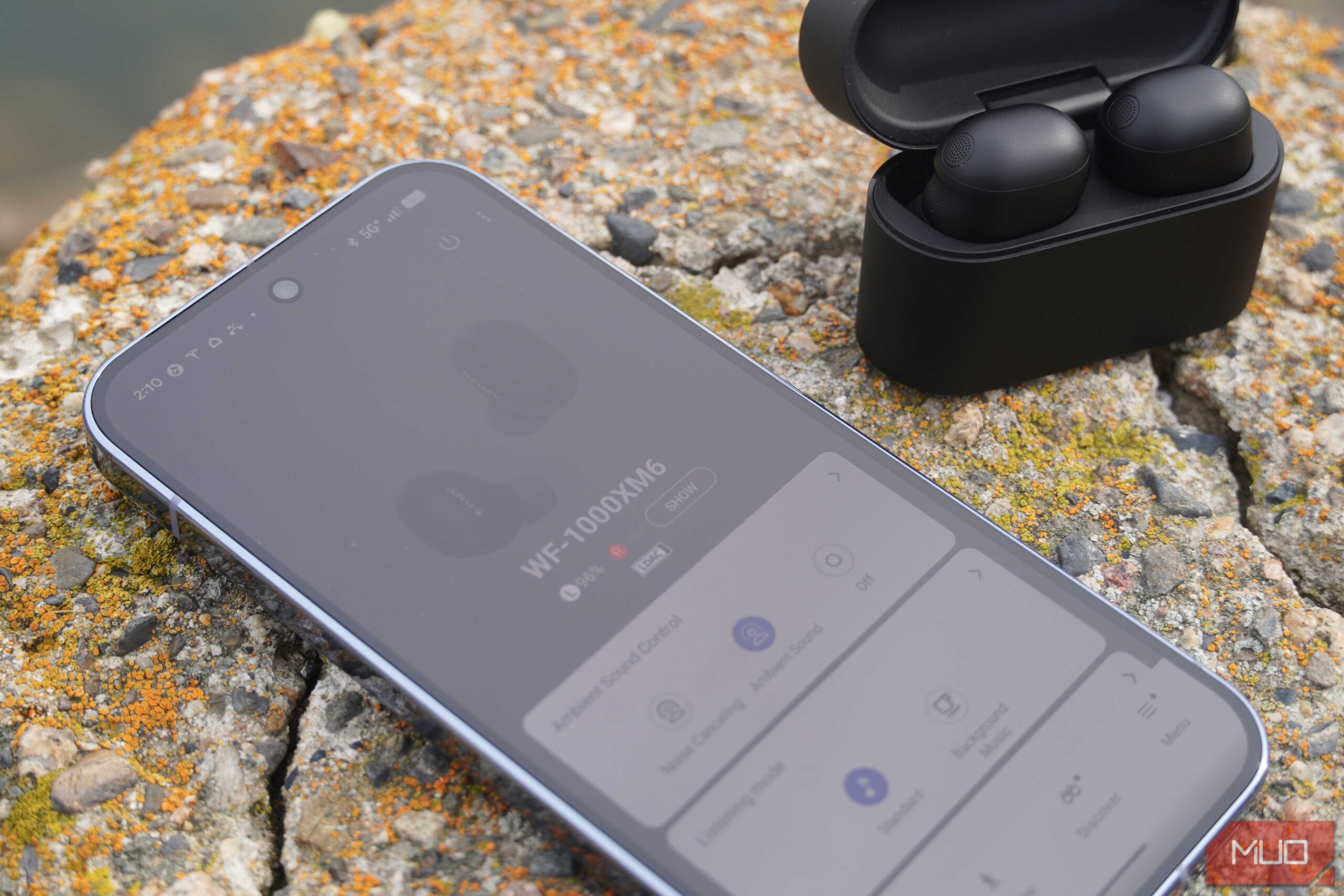 تنظیمات برنامه Sony WF-1000XM6 در کنار هدفونها.