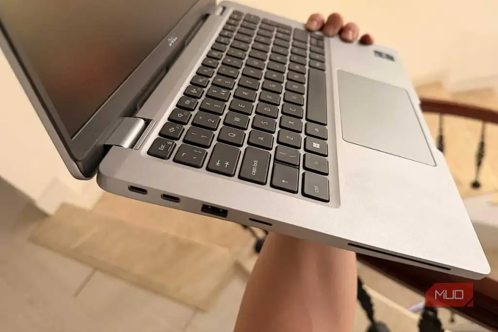 فردی که لپتاپ Dell Latitude را در دست دارد و پورتهای تاندربولت USB-C سمت چپ را نشان میدهد