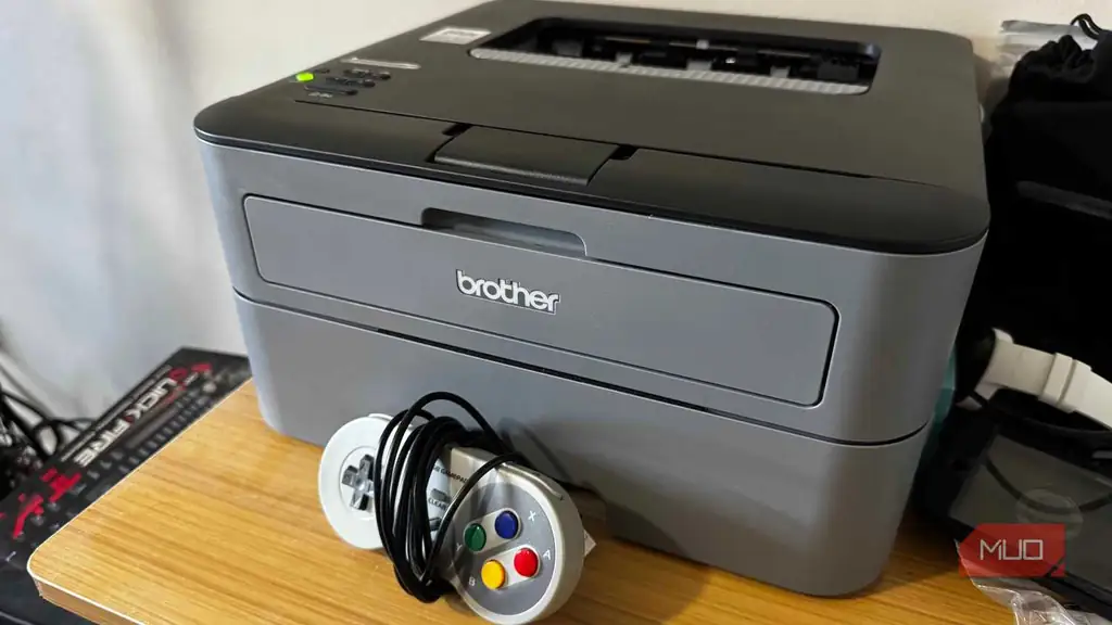 چاپگر Brother روی میز همراه با یک کنترلر SNES در جلوی آن