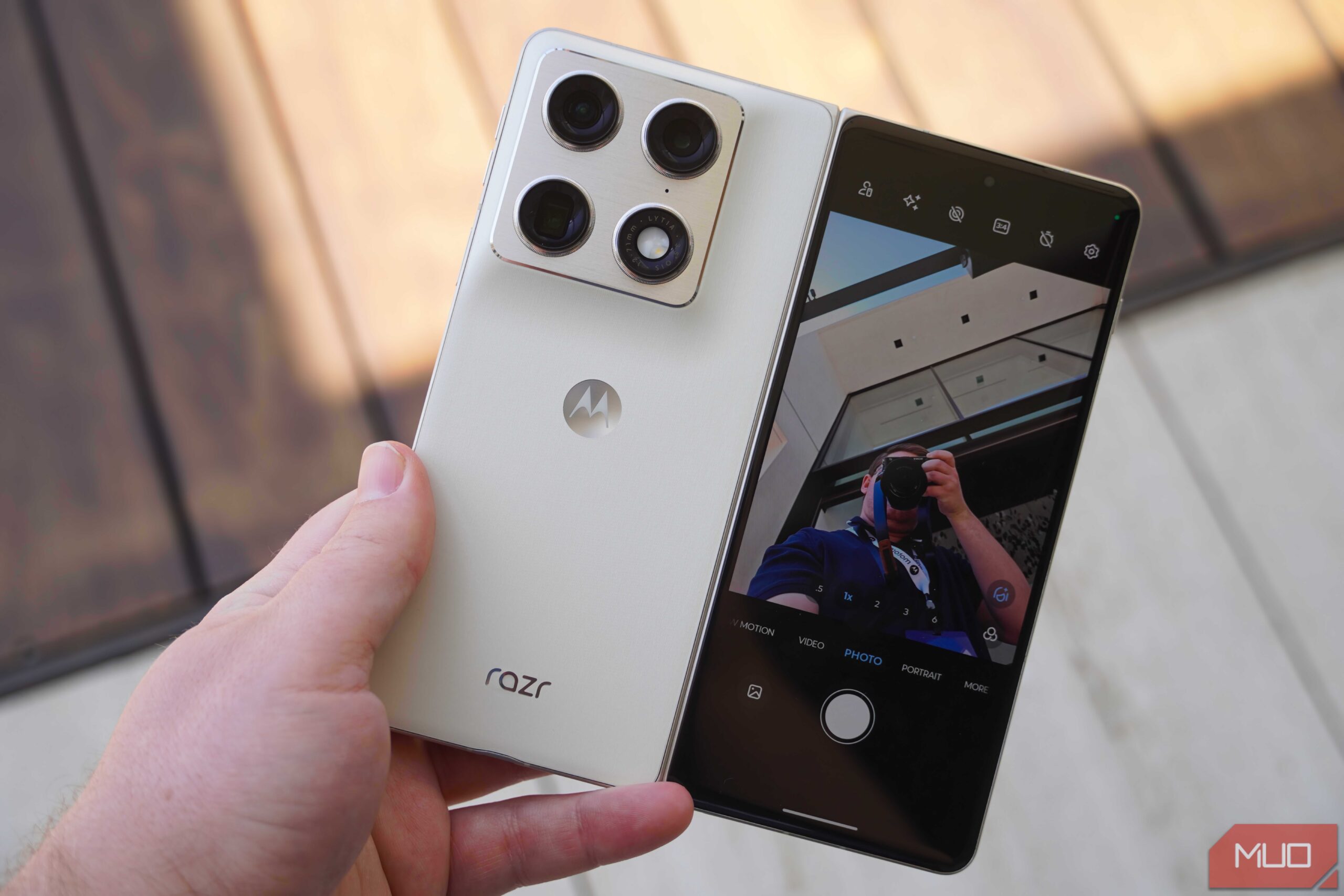 تصویری از The Motorola Razr Fold in the hand with the cover screen preview on.