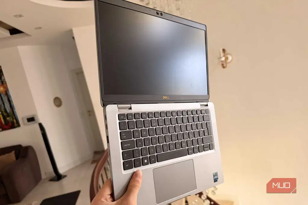 فردی که Dell Latitude را در دست دارد و درگاه‌های USB-C Thunderbolt آن را نشان می‌دهد
