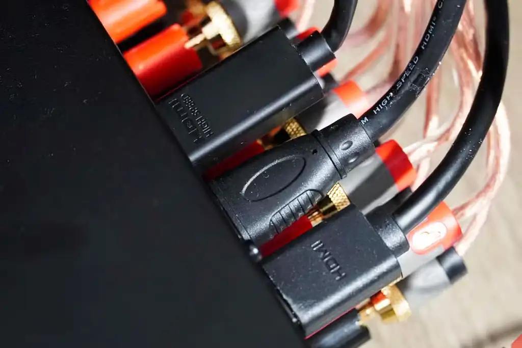 چند کابل HDMI متصل به درگاههای یک گیرنده صوتیتصویری.