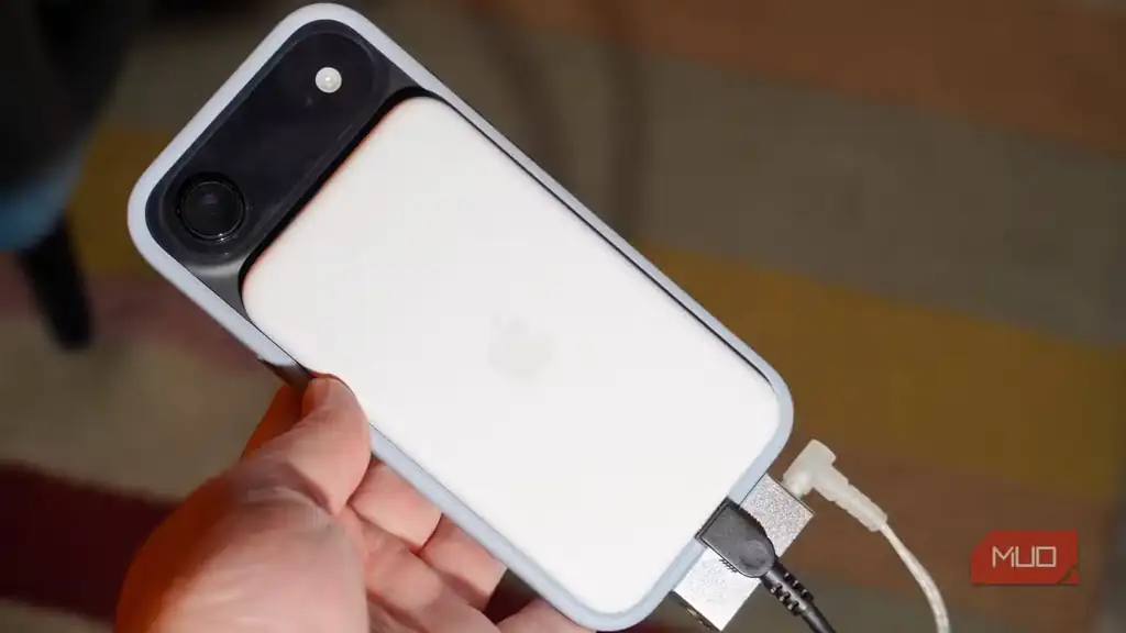 باتری MagSafe، دانگل DAC، شارژر و هدفون متصل به یک گوشی.