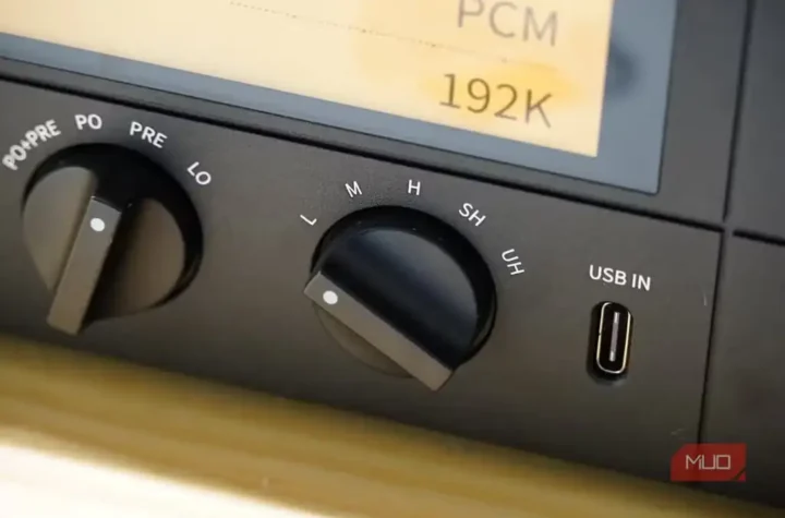 نمای نزدیک از کلید Gain روی DAC مدل Fiio K15 در کنار هدفون.