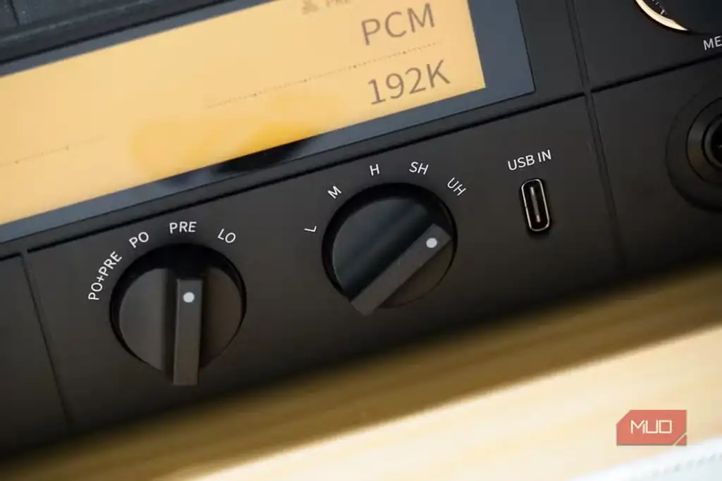 نمای نزدیک از کلید Gain روی DAC مدل Fiio K15 در کنار هدفون.