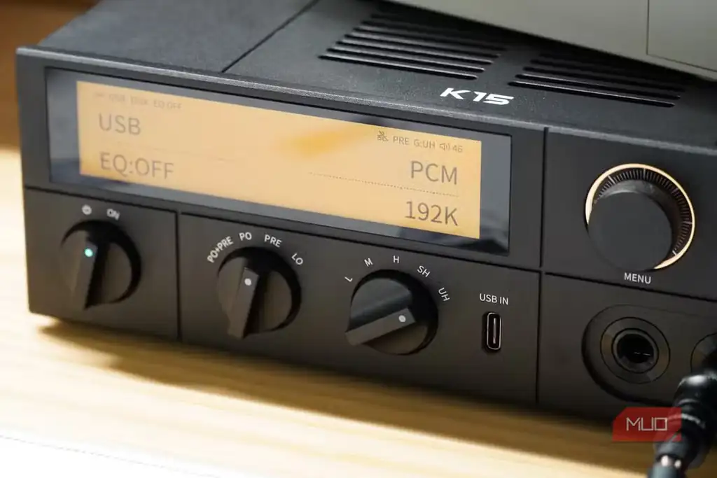 نمای نزدیک از کلید Gain روی DAC مدل Fiio K15 در کنار هدفون.