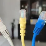 چند کابل Ethernet آبی، زرد و خاکستری برای اتصال پایدار شبکه خانگی.