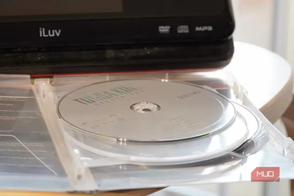 یک دیسک DVD مقابل پخشکننده قابلحمل، یادآور کاربرد فرمتهای قدیمیتر.