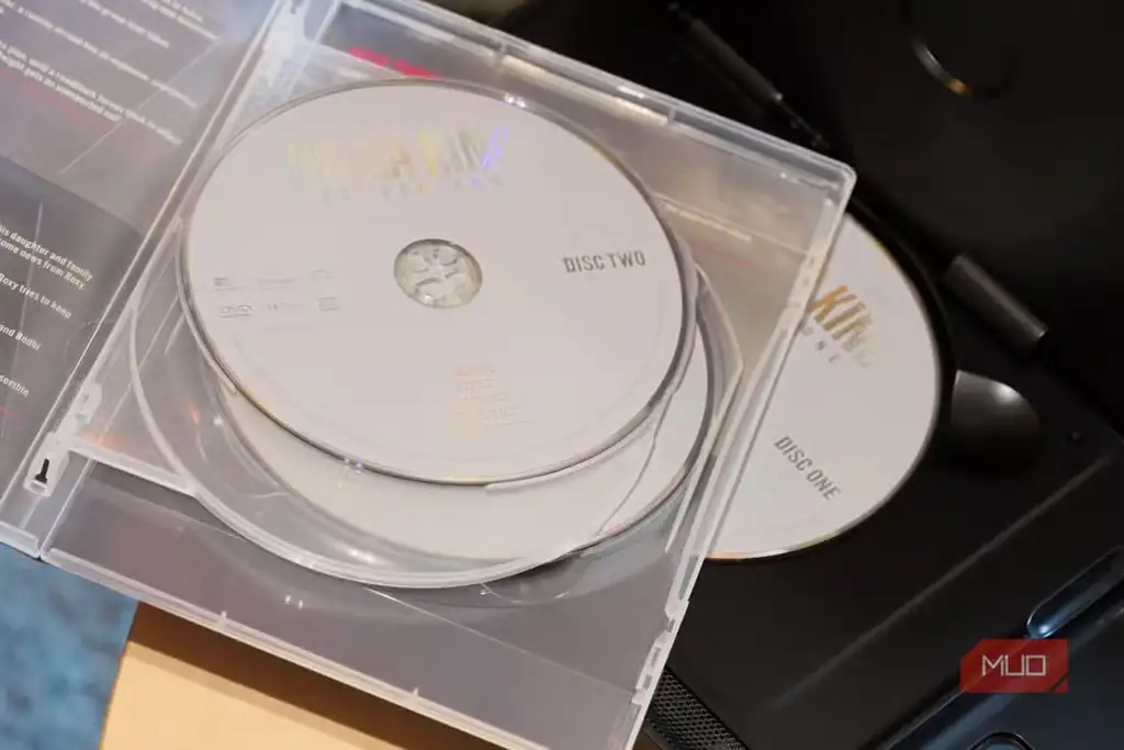 انبوهی از دیسکهای DVD روی پخشکننده برای نمایش خریدهای اقتصادی فیلم.