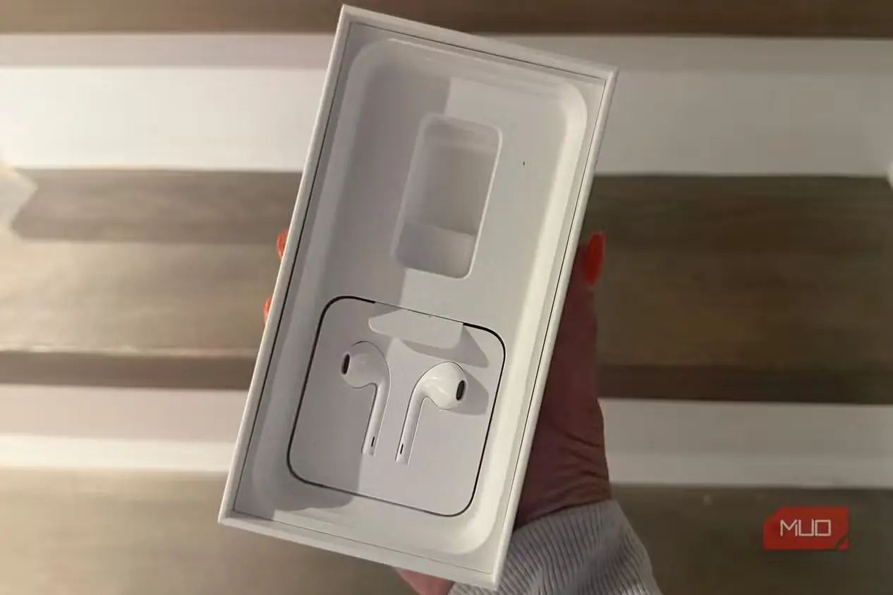 دستی در حال نگهداشتن جعبهٔ آیفون قدیمی با تصویر ایربادهای EarPods