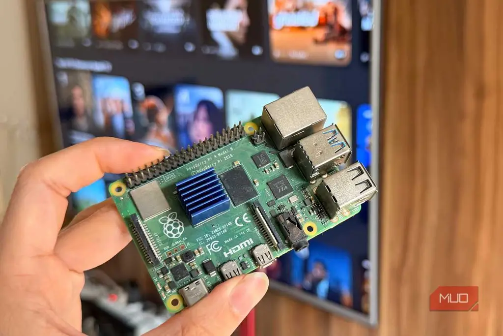 دستی که Raspberry Pi 4 را در مقابل تلویزیون هوشمند نگه داشته