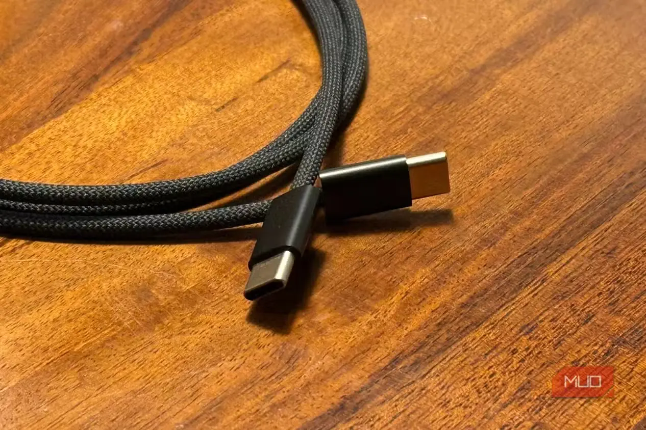 دو سر یک کابل USB-C به USB-C روی میز چوبی