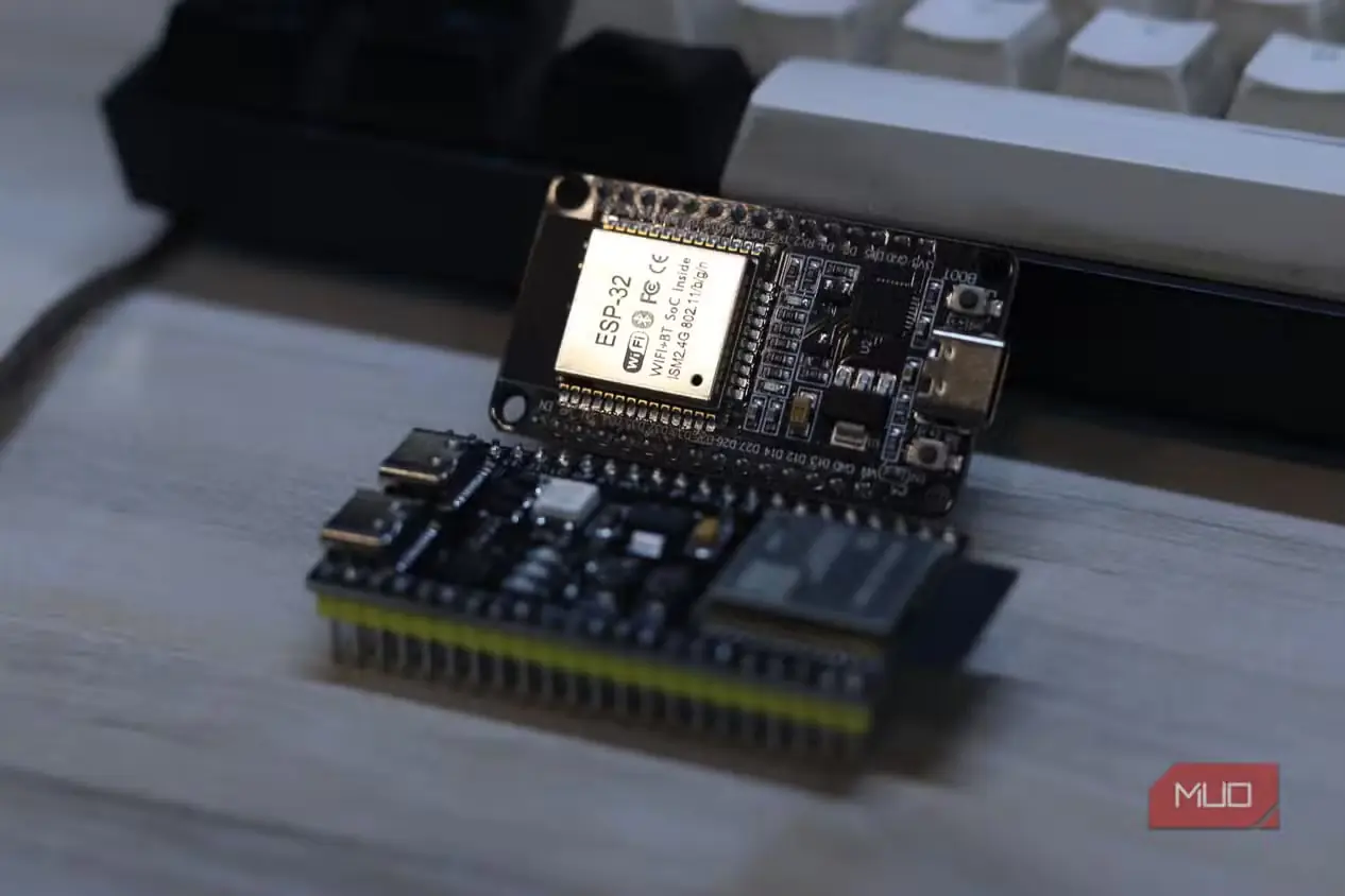 نمای نزدیک برچسب ماژول ESP32 کلاسیک، کنار برد ESP32‑S3 و صفحه‌کلید