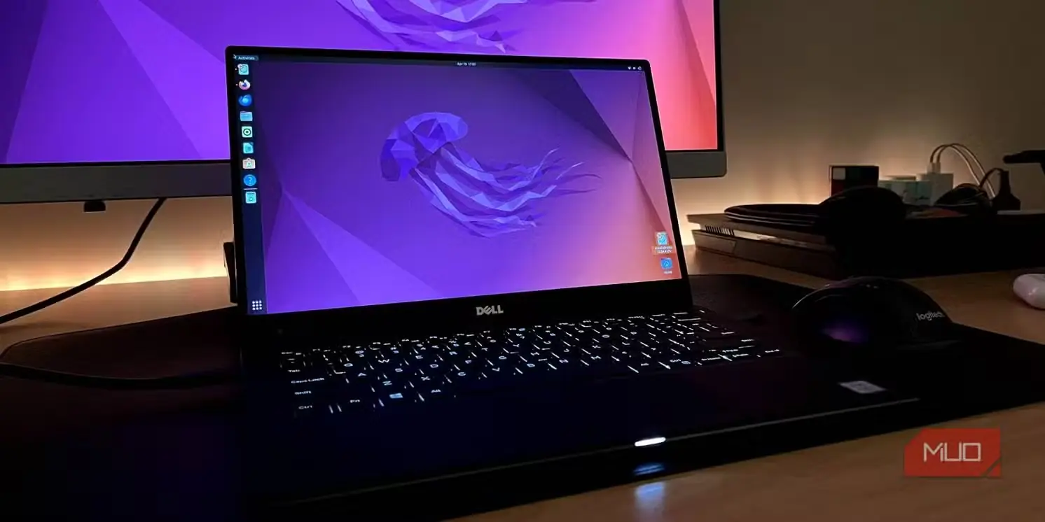 لپ‌تاپ Dell XPS 13 در حال اجرای اوبونتو با یک مانیتور در پس‌زمینه