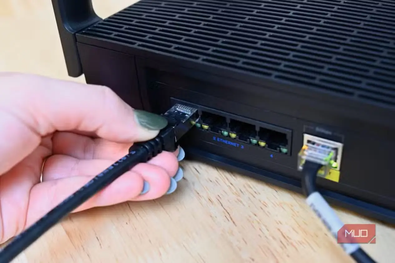 فردی در حال متصل کردن کابل اترنت Cable Matters به روتر