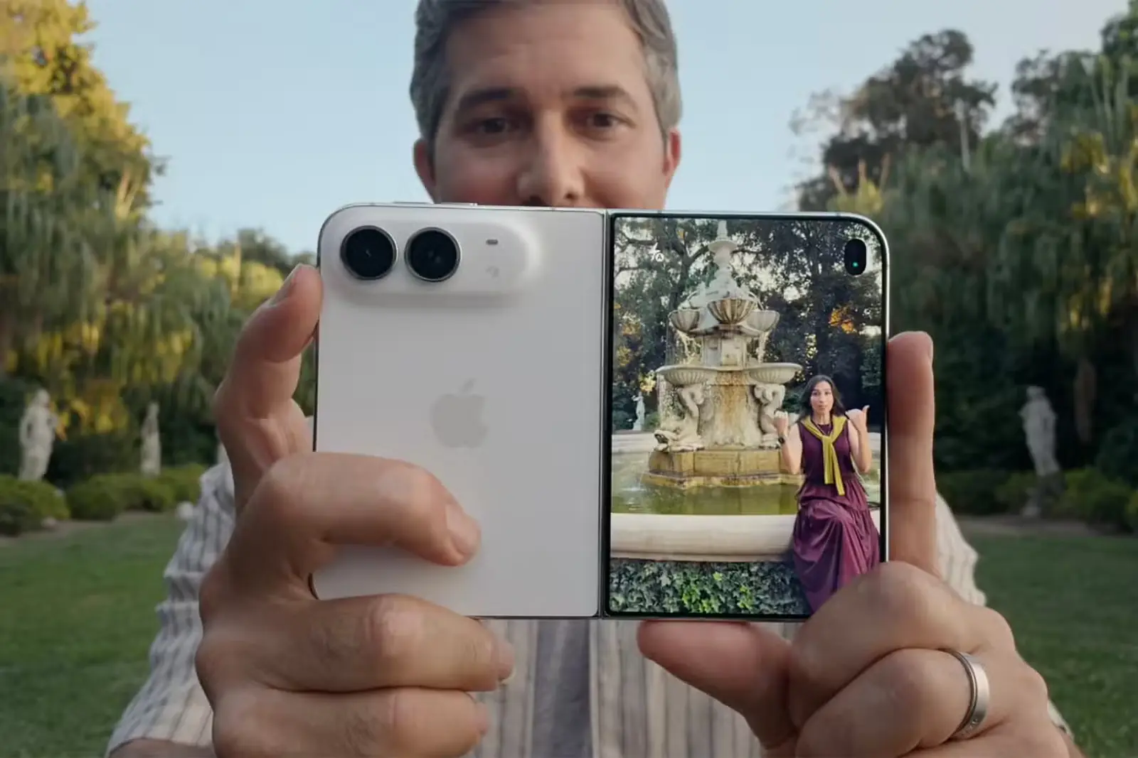 مردی در حال گرفتن Apple iPhone Duo روبهروی زنی که پیشنمایش تصویر او روی نمایشگر جلویی دیده میشود