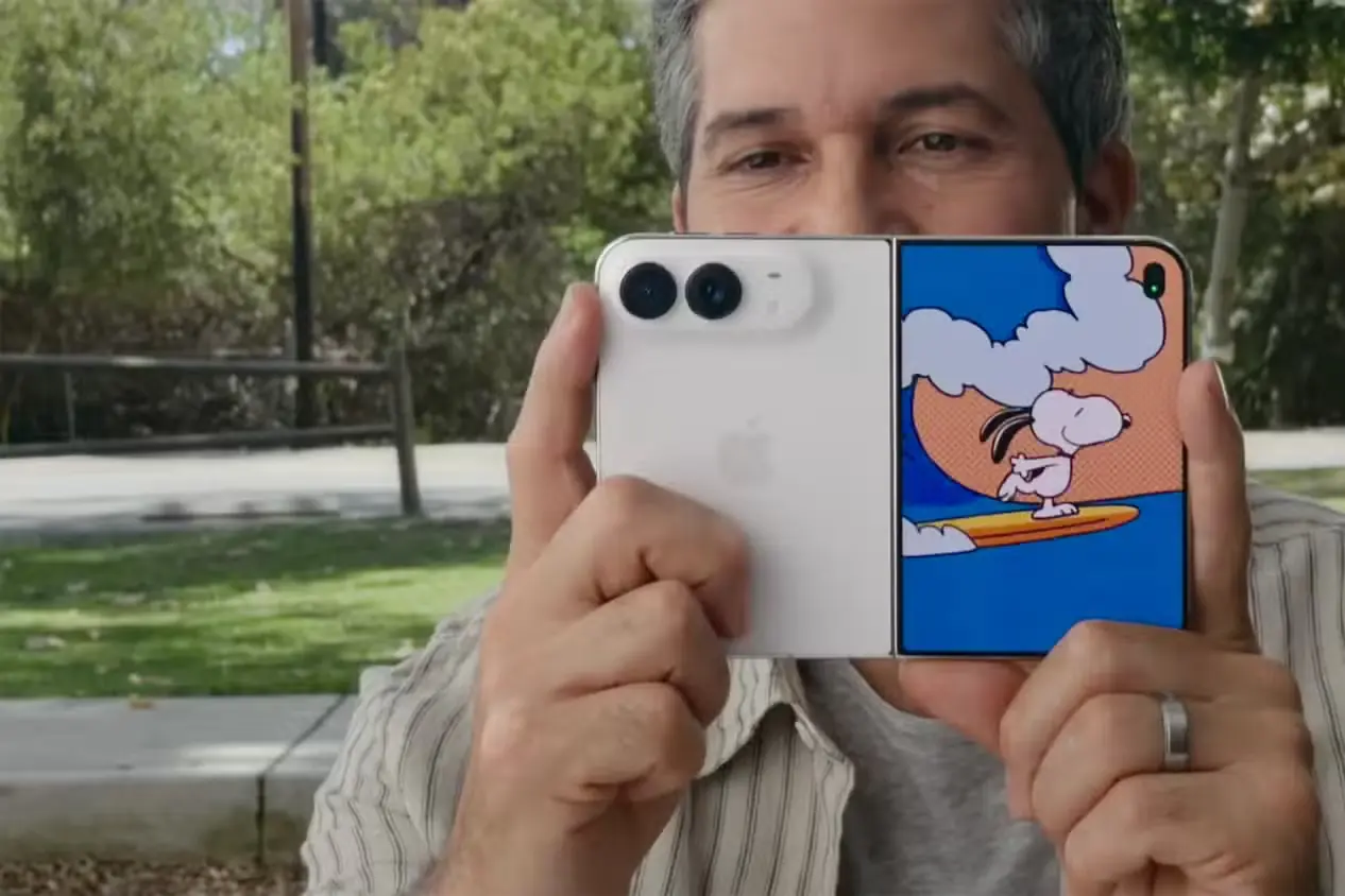 مردی در حال نگهداشتن Apple iPhone Duo با پویانمایی Kid Cue از Peanuts روی نمایشگر جلویی