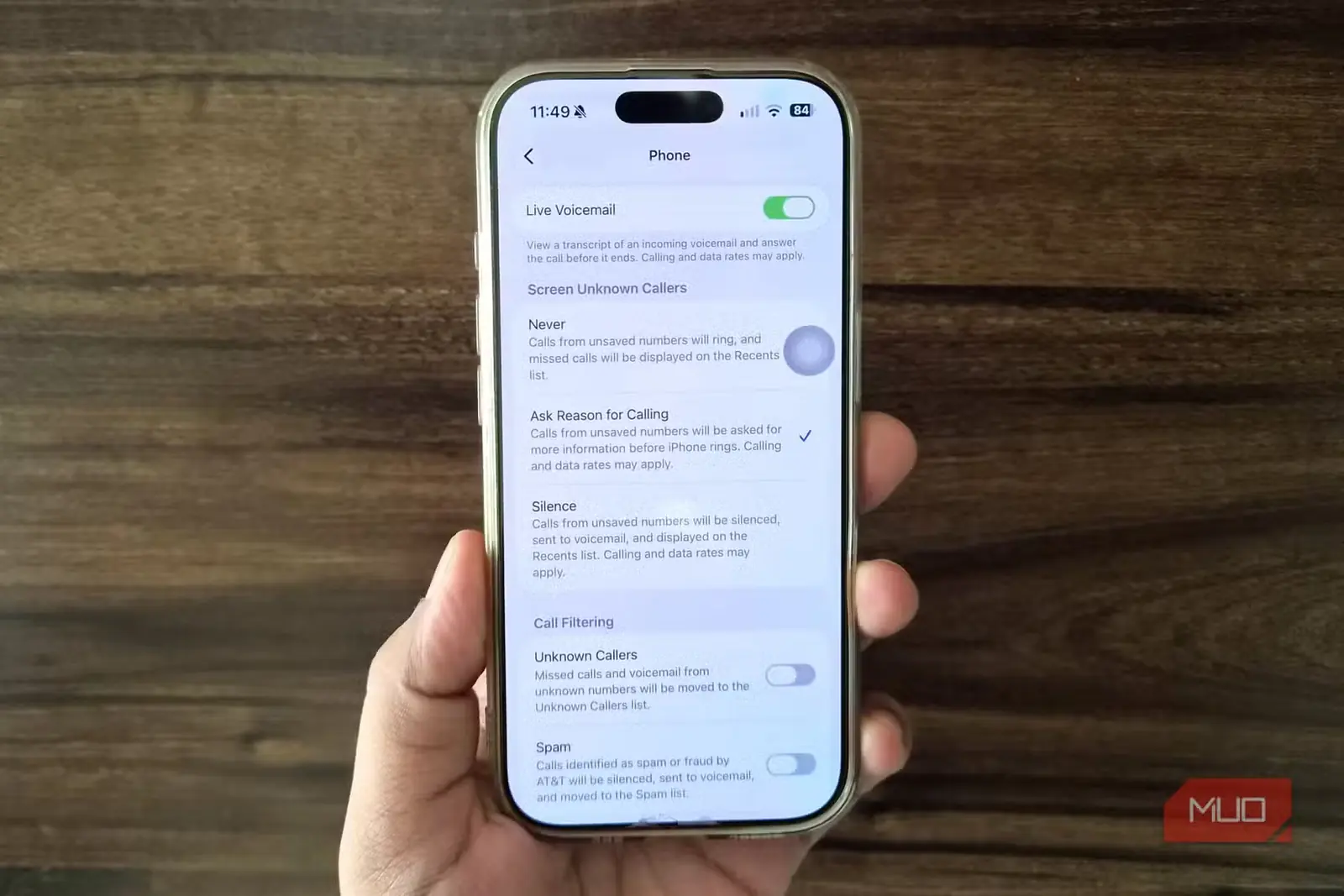 نمای iPhone در دست و تنظیمات برنامهٔ Phone روی صفحه