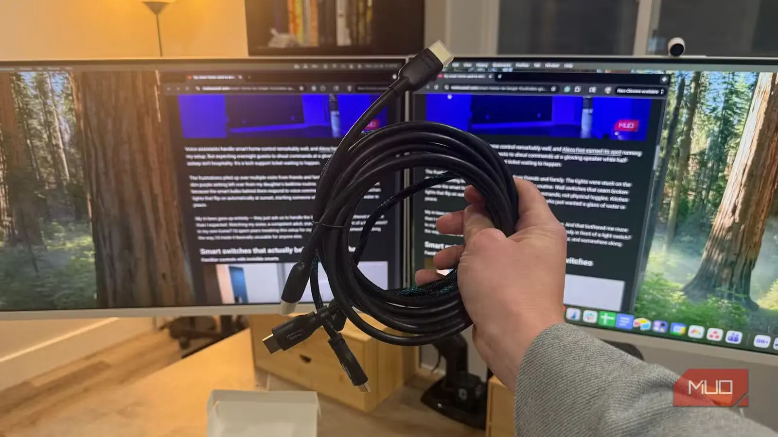 سه کابل HDMI در دست و دو نمایشگر در پسزمینه