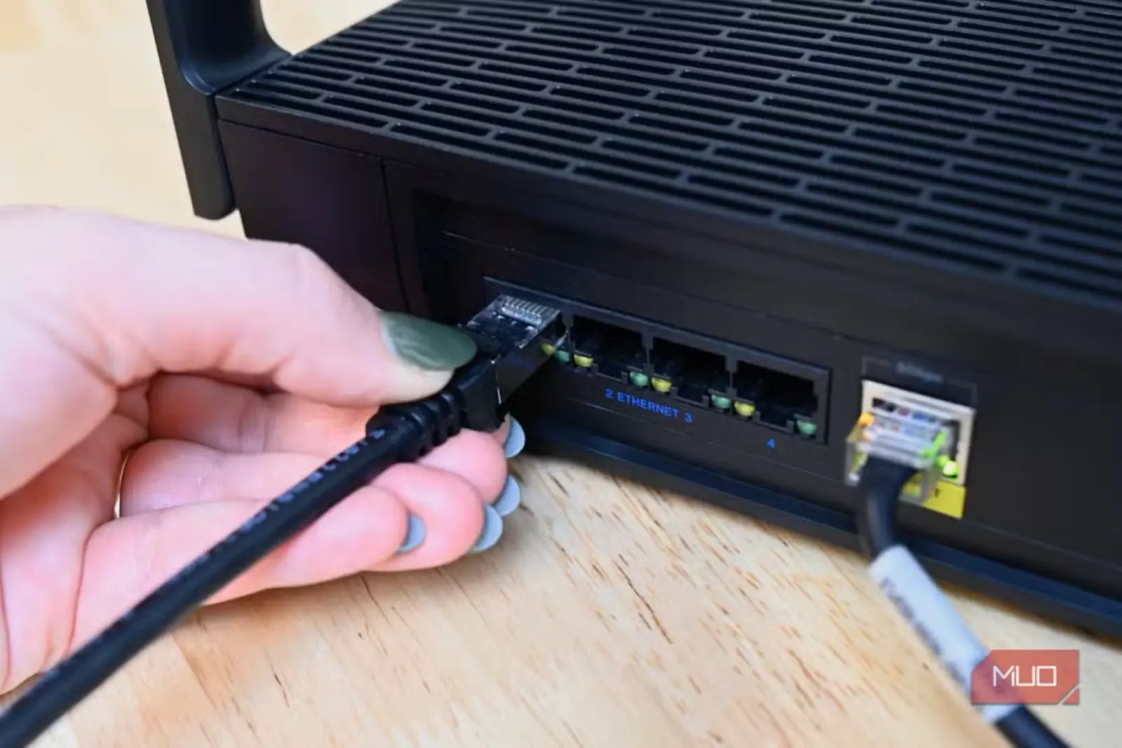 فردی در حال وصلکردن کابل اترنت Cable Matters به روتر