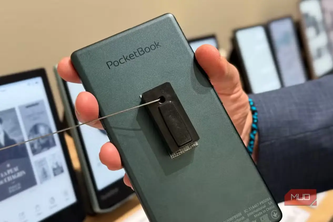 دستی در حال نگهداشتن پشت سبزرنگ PocketBook Q با بند امنیتی متصل