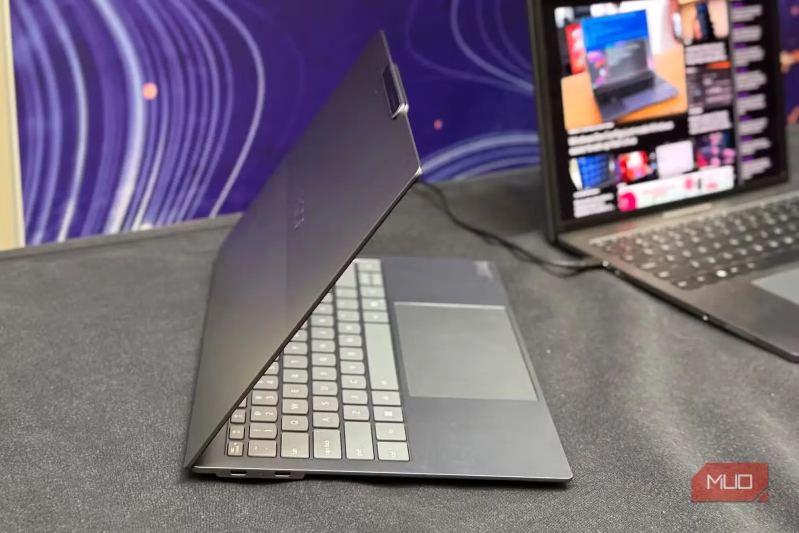 نمای جانبی یک ThinkPad باریک و باز روی میز، در کنار لپتاپی دیگر
