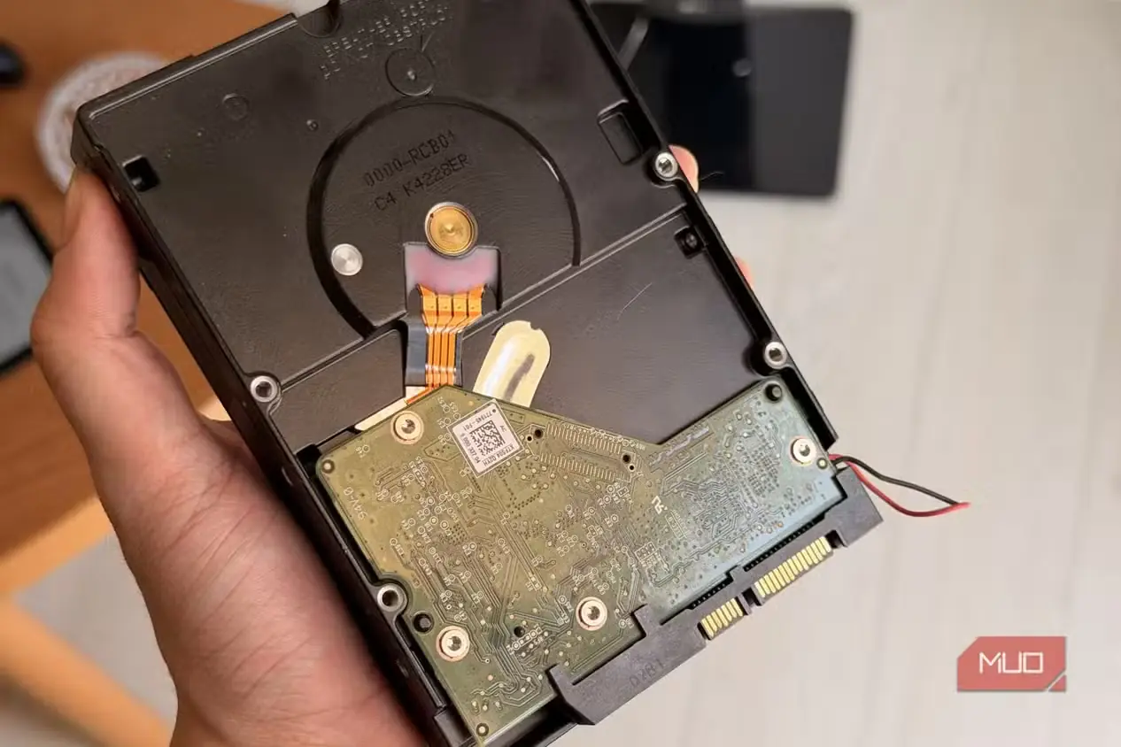 دستی در حال نگهداشتن هارد WD Red با پوشش برداشتهشده و مدار آشکار