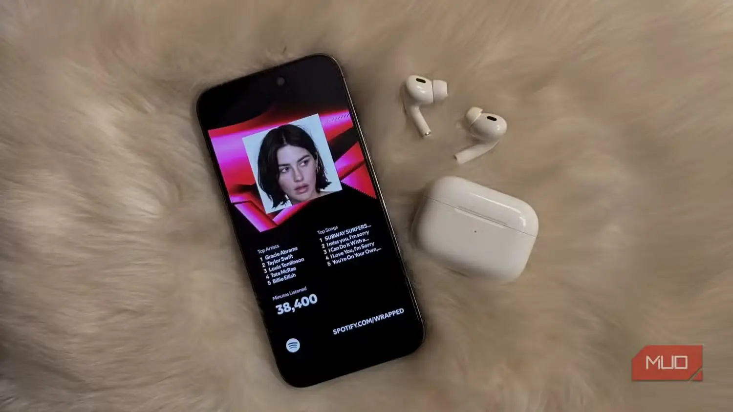 نمایش Spotify Wrapped روی یک iPhone در کنار AirPods
