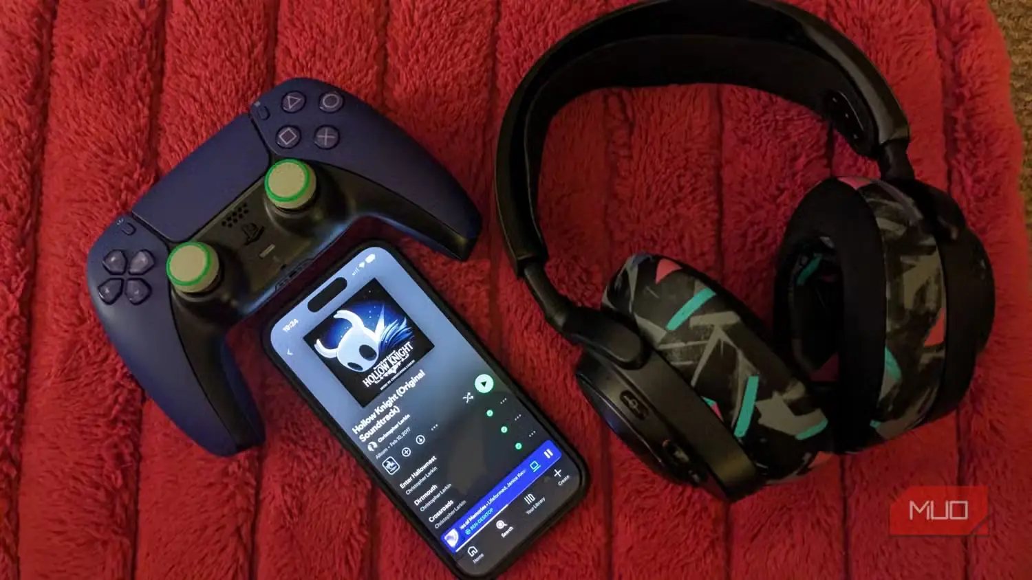 موسیقی متن هالو نایت در Spotify کنار دستهٔ PS5 و هدفون