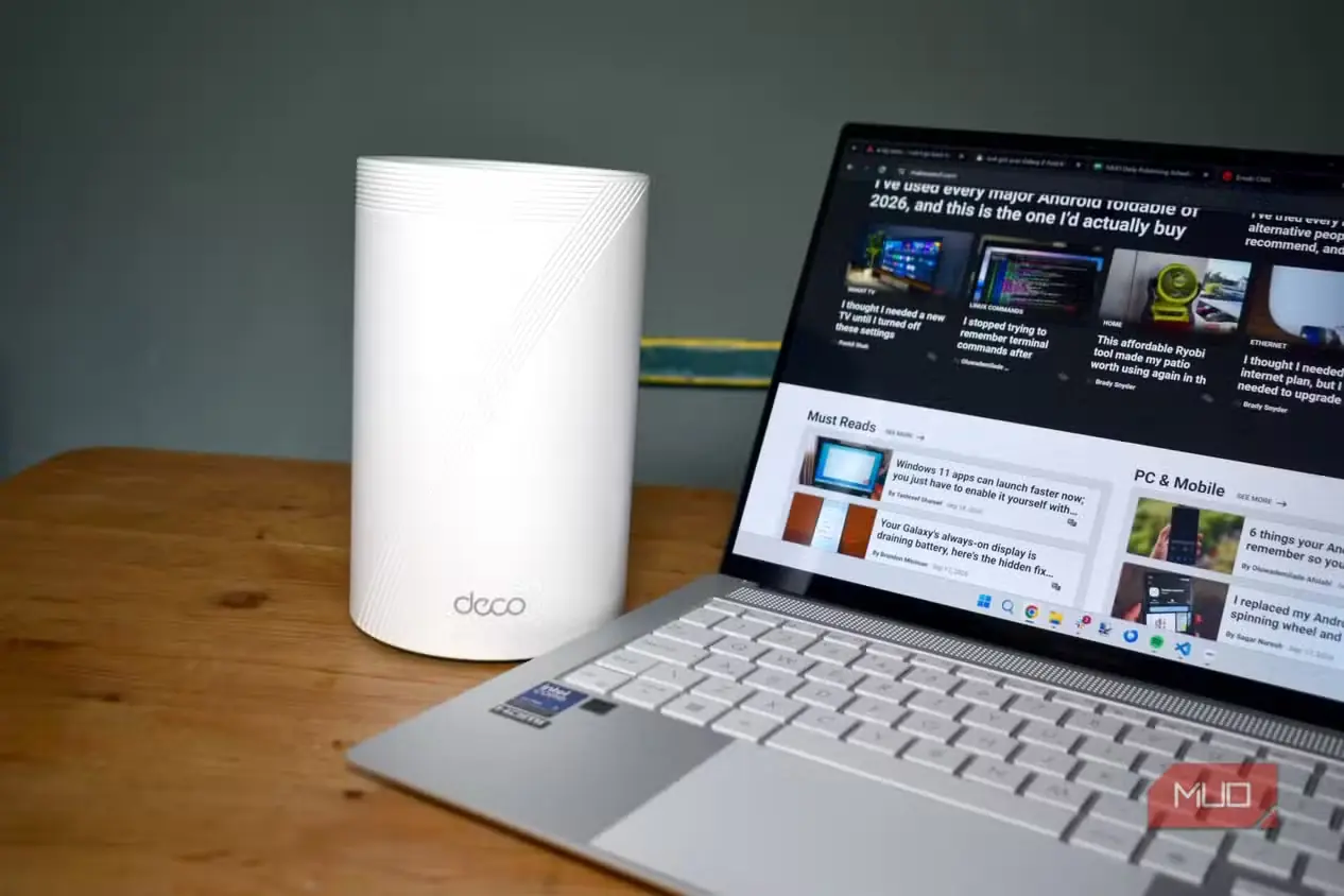 روتر TP-Link Deco BE65 با Wi-Fi 7 روی میز و لپتاپِ باز